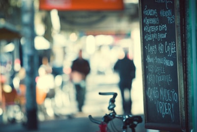 红色和灰色的自行车停在黑色黑板附近，上面写着菜单，可选择聚焦摄影